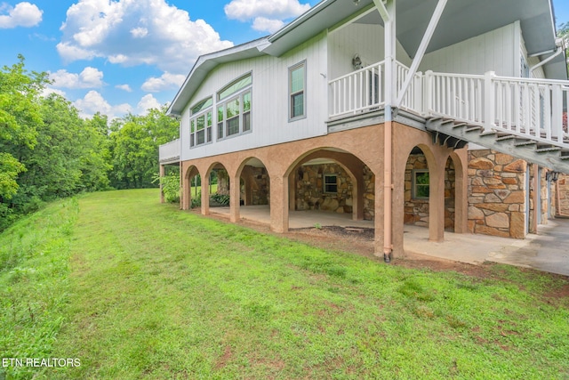 363 Staghorn Ln, Seymour, TN 37865 - back of property featuring a yard, a patio, stone siding, and a balcony