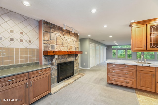 363 Staghorn Ln, Seymour, TN 37865 - kitchen with recessed lighting, a fireplace, glass insert cabinets, backsplash, and brown cabinets