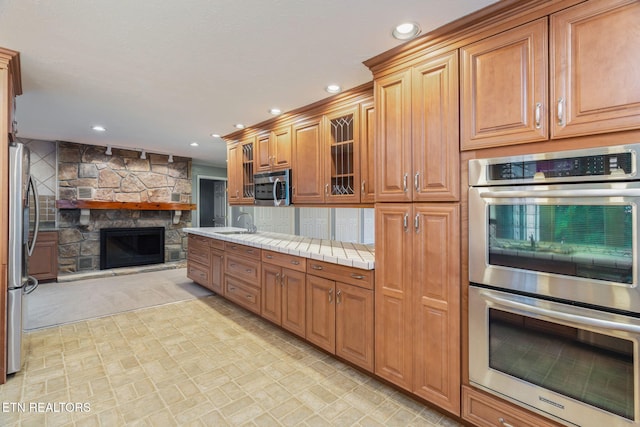 363 Staghorn Ln, Seymour, TN 37865 - kitchen featuring appliances with stainless steel finishes, open floor plan, glass insert cabinets, recessed lighting, and a fireplace