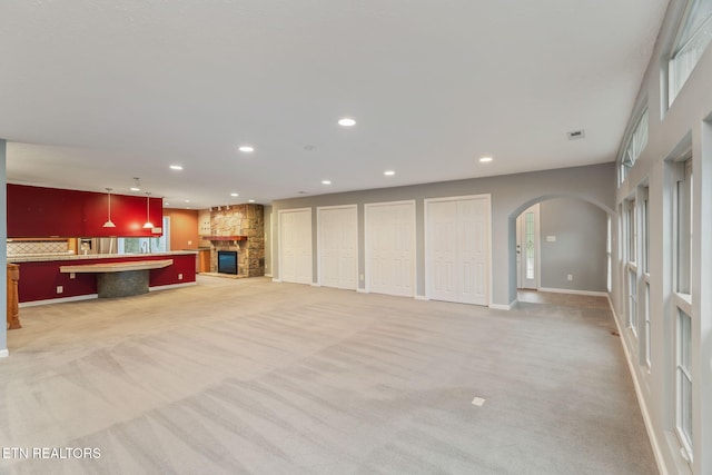 363 Staghorn Ln, Seymour, TN 37865 - unfurnished living room featuring light colored carpet, arched walkways, a fireplace, and recessed lighting