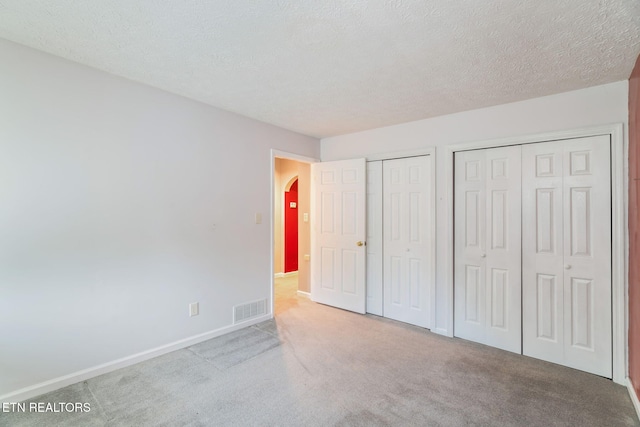 363 Staghorn Ln, Seymour, TN 37865 - unfurnished bedroom featuring two closets, carpet flooring, and arched walkways