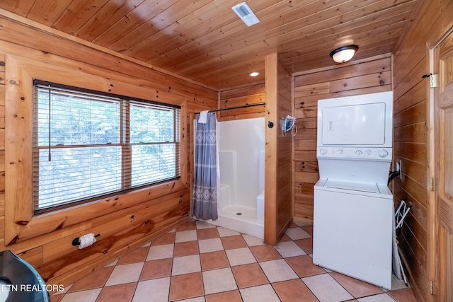 1032 Black Bear Cub Way, Sevierville, TN 37862 - laundry area featuring stacked washer and clothes dryer, wood walls, wooden ceiling, and light tile patterned floors