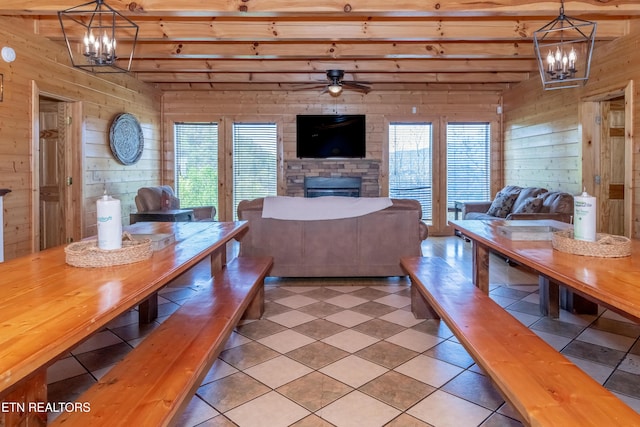 1032 Black Bear Cub Way, Sevierville, TN 37862 - dining space with wood walls, a chandelier, beam ceiling, ceiling fan, and a fireplace