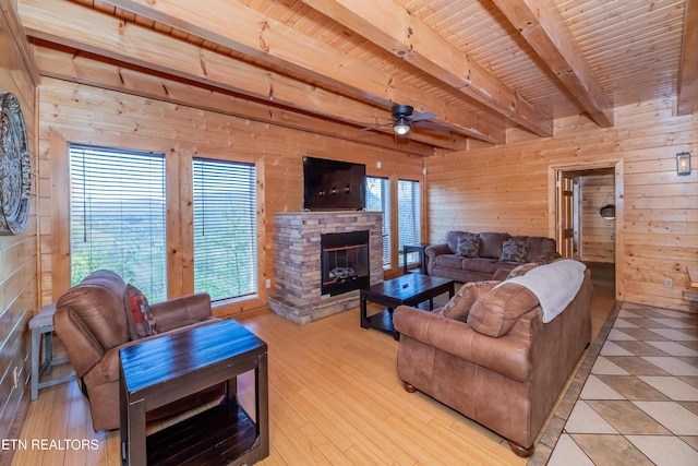 1032 Black Bear Cub Way, Sevierville, TN 37862 - living area with wooden walls, a ceiling fan, plenty of natural light, light wood finished floors, and a stone fireplace