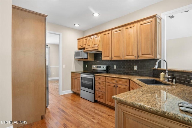 171 Forest Cove Ct, Jacksboro, TN 37757 - kitchen with appliances with stainless steel finishes, light stone counters, decorative backsplash, light wood-style flooring, and recessed lighting