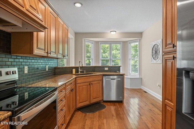 171 Forest Cove Ct, Jacksboro, TN 37757 - kitchen featuring appliances with stainless steel finishes, premium range hood, decorative backsplash, light wood-style flooring, and a peninsula