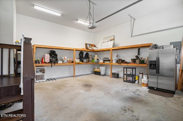 171 Forest Cove Ct, Jacksboro, TN 37757 - garage with stainless steel refrigerator with ice dispenser, a workshop area, and a garage door opener