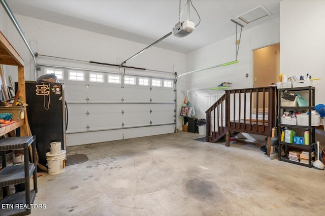171 Forest Cove Ct, Jacksboro, TN 37757 - garage featuring a garage door opener and freestanding refrigerator