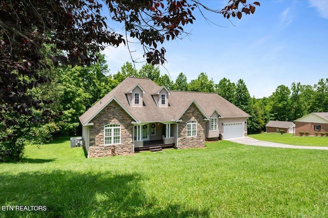 171 Forest Cove Ct, Jacksboro, TN 37757 - view of front of house featuring stone siding, covered porch, a garage, driveway, and a front lawn