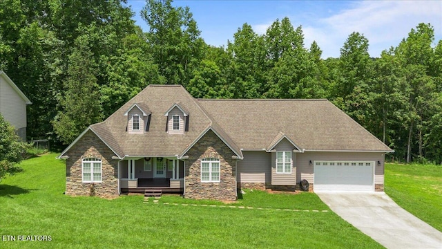 171 Forest Cove Ct, Jacksboro, TN 37757 - view of front of home with stone siding, a garage, driveway, a front yard, and a porch