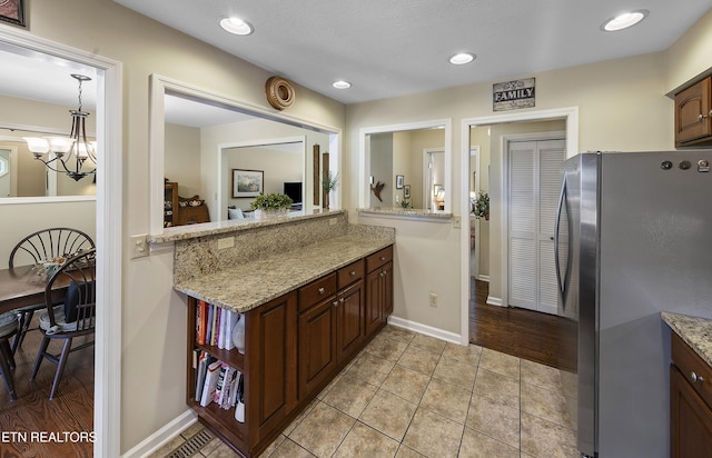 302 Lake St, Harriman, TN 37748 - kitchen with freestanding refrigerator, light tile patterned flooring, recessed lighting, a chandelier, and light stone countertops