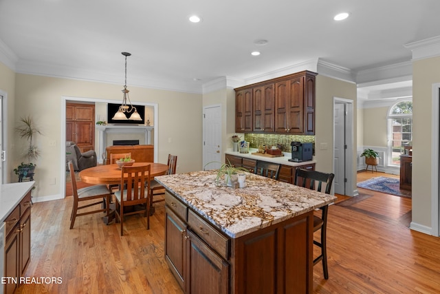 112 Reed Cir, Johnson City, TN 37601 - kitchen featuring a breakfast bar area, ornamental molding, light wood-style flooring, backsplash, and a center island