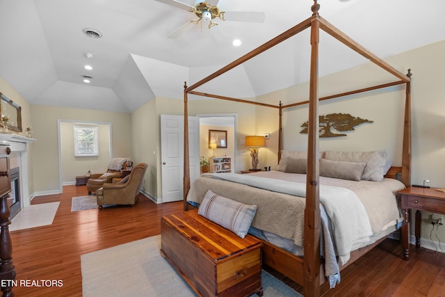 112 Reed Cir, Johnson City, TN 37601 - bedroom featuring wood finished floors, vaulted ceiling, a fireplace with flush hearth, and ceiling fan