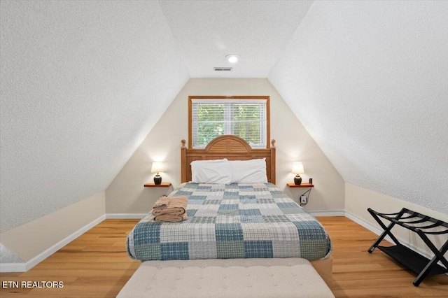 824 Deerfield Way, Lafollette, TN 37766 - bedroom featuring a textured ceiling, lofted ceiling, and wood finished floors