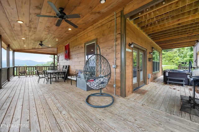 3169 Bear Mountain Ln, Sevierville, TN 37876 - wooden terrace featuring a hot tub, outdoor dining area, ceiling fan, a mountain view, and french doors