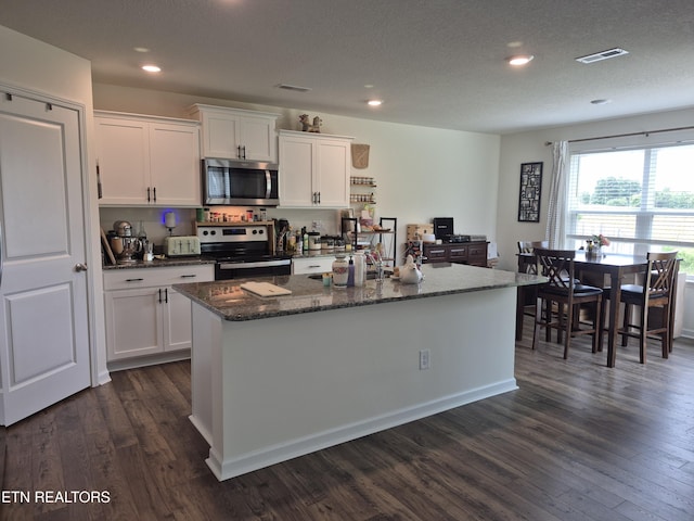 7515 Grasshopper Ln, Corryton, TN 37721 - kitchen featuring stainless steel appliances, dark wood-style flooring, white cabinetry, a kitchen island with sink, and recessed lighting