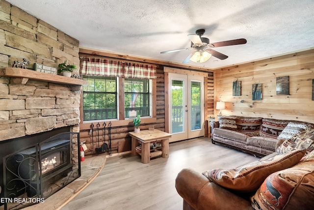 509 Thomas Loop Rd, Sevierville, TN 37876 - living area featuring a textured ceiling, light wood-style floors, ceiling fan, french doors, and wooden walls