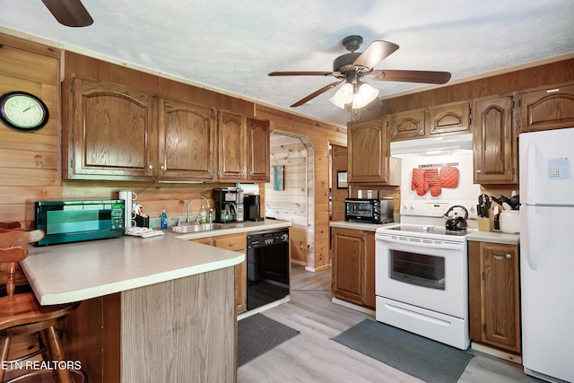 509 Thomas Loop Rd, Sevierville, TN 37876 - kitchen featuring black appliances, under cabinet range hood, wood walls, a peninsula, and ceiling fan