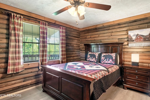 509 Thomas Loop Rd, Sevierville, TN 37876 - bedroom with log walls, light wood-style floors, a textured ceiling, and a ceiling fan