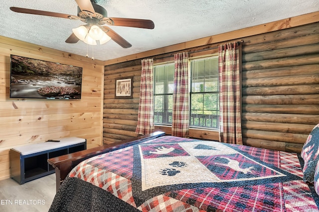 509 Thomas Loop Rd, Sevierville, TN 37876 - bedroom with log walls, a textured ceiling, wood finished floors, and a ceiling fan