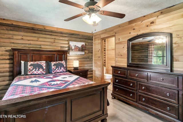 509 Thomas Loop Rd, Sevierville, TN 37876 - bedroom with rustic walls, a textured ceiling, light wood finished floors, connected bathroom, and a ceiling fan