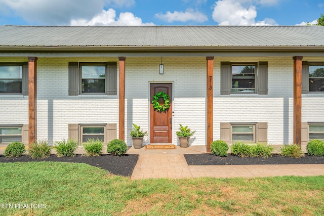 713 Concord Rd, Knoxville, TN 37934 - view of front of home with brick siding, a metal roof, and a front lawn