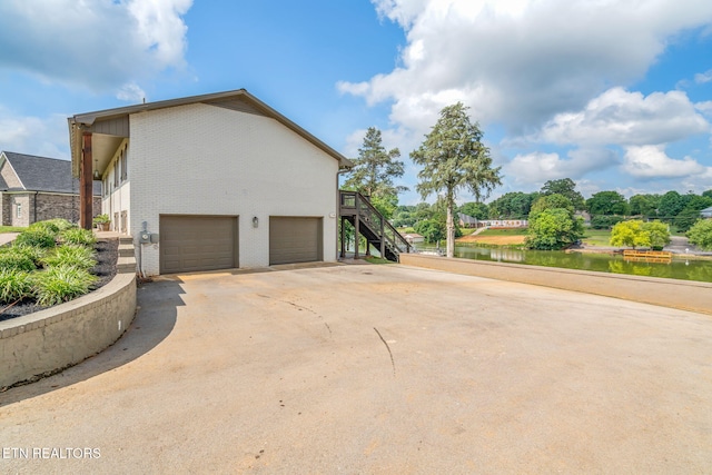 713 Concord Rd, Knoxville, TN 37934 - view of property exterior featuring an attached garage, brick siding, concrete driveway, and stairway