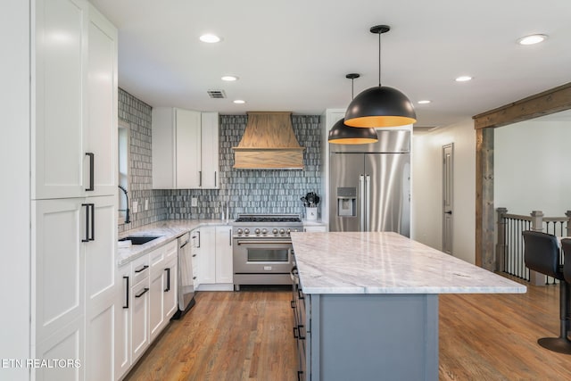 713 Concord Rd, Knoxville, TN 37934 - kitchen featuring appliances with stainless steel finishes, premium range hood, a kitchen island, backsplash, and white cabinetry