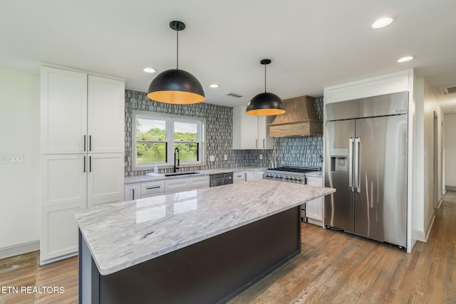 713 Concord Rd, Knoxville, TN 37934 - kitchen with premium appliances, premium range hood, wood finished floors, white cabinetry, and light stone counters