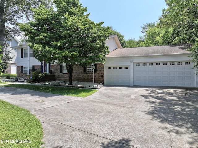 616 Loop Rd, Knoxville, TN 37934 - obstructed view of property with concrete driveway, a garage, and brick siding