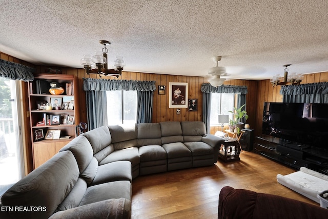 616 Loop Rd, Knoxville, TN 37934 - living room with a chandelier, wooden walls, wood finished floors, and a textured ceiling