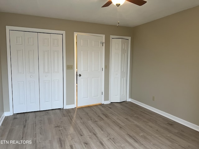 112 Olympia Dr, Alcoa, TN 37701 - unfurnished bedroom featuring wood finished floors, a ceiling fan, and two closets