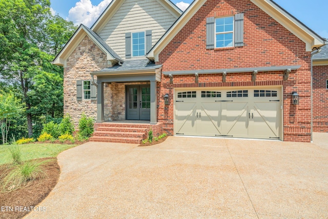 1100 Regality Way, Knoxville, TN 37923 - view of front of house featuring concrete driveway, an attached garage, stone siding, and french doors