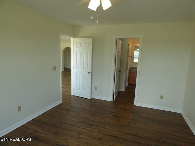 363 Smith Rd, Crossville, TN 38571 - unfurnished bedroom featuring dark wood-type flooring, arched walkways, connected bathroom, and a ceiling fan