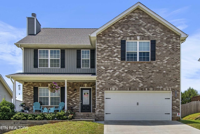 1152 Cloud View Dr, Powell, TN 37849 - traditional-style house featuring a porch, board and batten siding, a garage, a chimney, and brick siding
