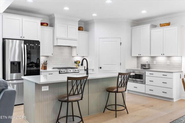 12845 Scarlet Sage Dr, Farragut, TN 37934 - kitchen with appliances with stainless steel finishes, decorative backsplash, white cabinets, light countertops, and a kitchen bar