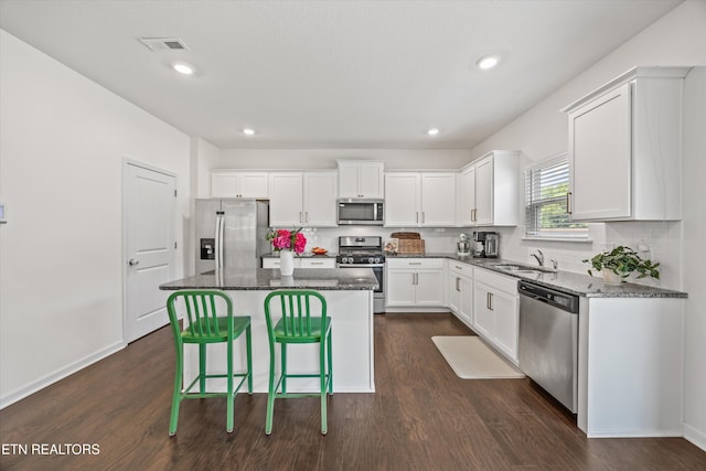 1171 Hampton Place Cir, Loudon, TN 37774 - kitchen featuring appliances with stainless steel finishes, dark wood-style floors, a center island, white cabinetry, and dark stone counters