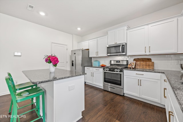 1171 Hampton Place Cir, Loudon, TN 37774 - kitchen with stainless steel appliances, white cabinetry, decorative backsplash, a center island, and dark stone counters