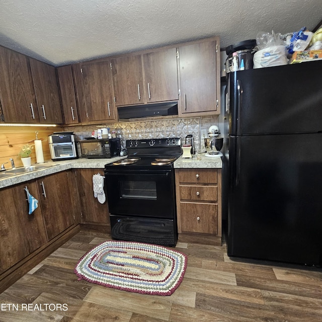 1911 Branam Hill Rd, Jellico, TN 37762 - kitchen featuring black appliances, under cabinet range hood, dark wood-style floors, light countertops, and a textured ceiling