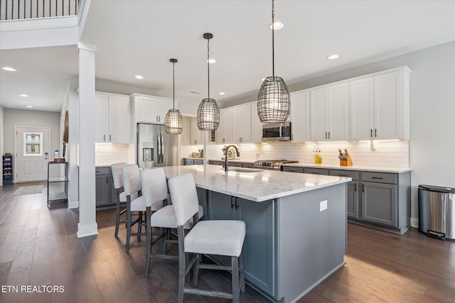 1682 Hickory Reserve Rd, Knoxville, TN 37932 - kitchen with appliances with stainless steel finishes, dark wood-type flooring, tasteful backsplash, gray cabinetry, and an island with sink