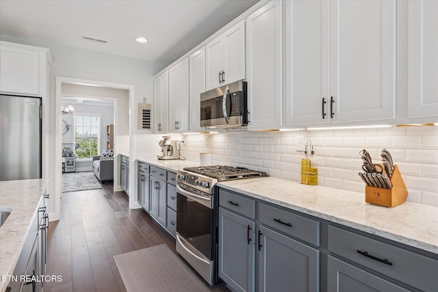 1682 Hickory Reserve Rd, Knoxville, TN 37932 - kitchen with stainless steel appliances, white cabinets, dark wood-type flooring, gray cabinets, and light stone counters