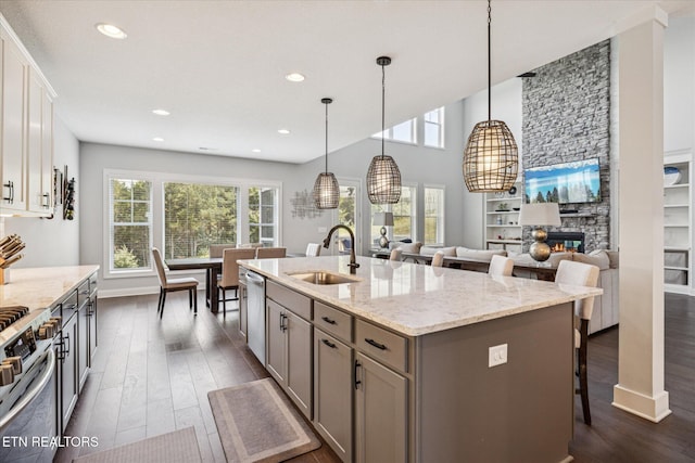 1682 Hickory Reserve Rd, Knoxville, TN 37932 - kitchen featuring stainless steel range oven, dark wood-style flooring, a kitchen island with sink, gray cabinets, and a kitchen bar