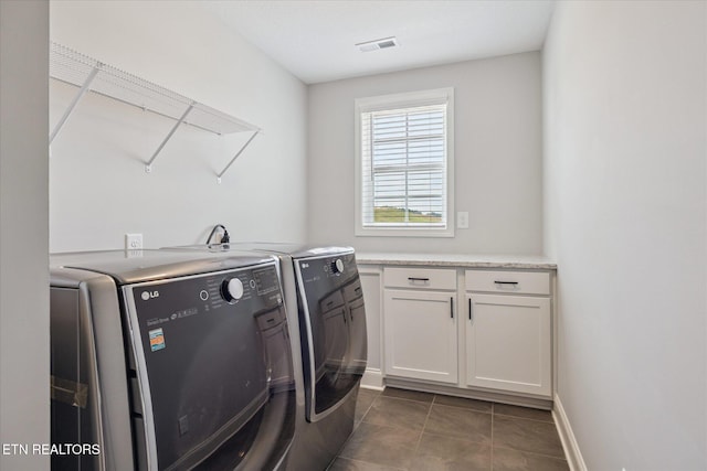 1682 Hickory Reserve Rd, Knoxville, TN 37932 - washroom with washer and dryer, dark tile patterned flooring, and cabinet space