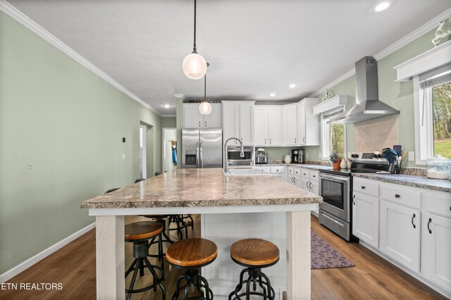 238 Mac Ivey Ln, Lafollette, TN 37766 - kitchen featuring stainless steel appliances, wall chimney exhaust hood, dark wood-type flooring, a kitchen island with sink, and crown molding