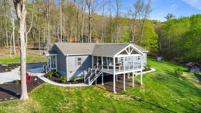 238 Mac Ivey Ln, Lafollette, TN 37766 - rear view of property featuring a trampoline, roof with shingles, a wooded view, crawl space, and a lawn