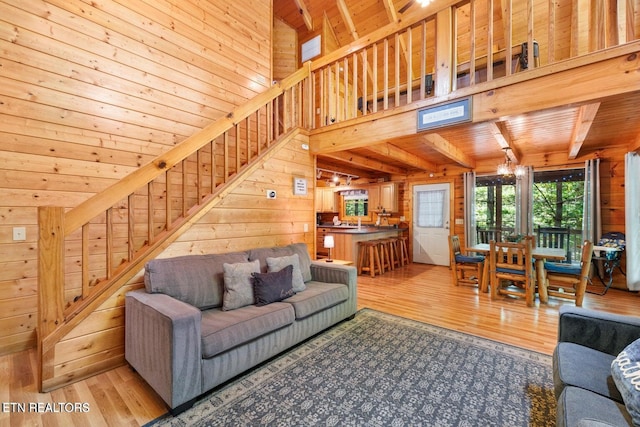 2217 Red Bud Rd, Sevierville, TN 37876 - living room with wood finished floors, wood walls, stairway, a chandelier, and a wooden ceiling with exposed beams