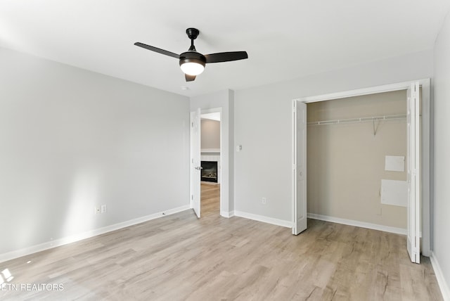 8808 Cedar Springs Ln, Knoxville, TN 37923 - unfurnished bedroom featuring light wood-style floors, a closet, a tiled fireplace, and ceiling fan