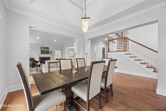 1269 Bentley Park Ln, Knoxville, TN 37922 - dining space with stairway, a fireplace, wood-type flooring, a chandelier, and crown molding