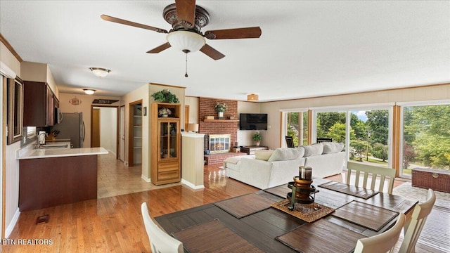300 Clearfield Rd, Knoxville, TN 37922 - dining space with light wood-style flooring, ceiling fan, and a fireplace