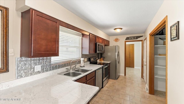 300 Clearfield Rd, Knoxville, TN 37922 - kitchen featuring appliances with stainless steel finishes, decorative backsplash, a textured ceiling, light stone countertops, and light stone finish flooring